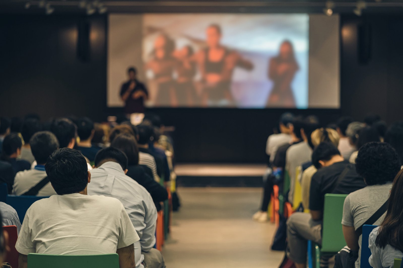 Rear view of Asian audience joining and listening speaker talking on the stage in the seminar meeting room or conference hall, education and workshop, associate and startup business concept